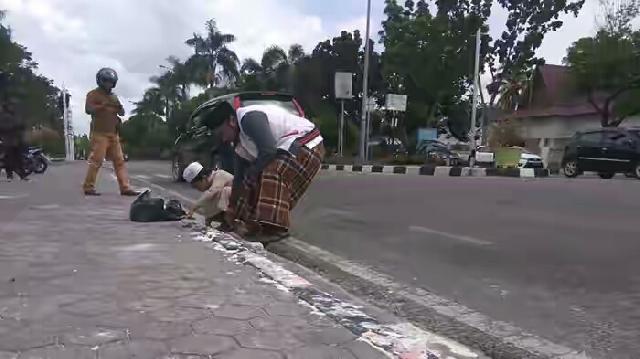 Said dan Sang Anak Bersihkan Kerak Lilin Sisa Aksi Semalam di Jalan Diponegoro